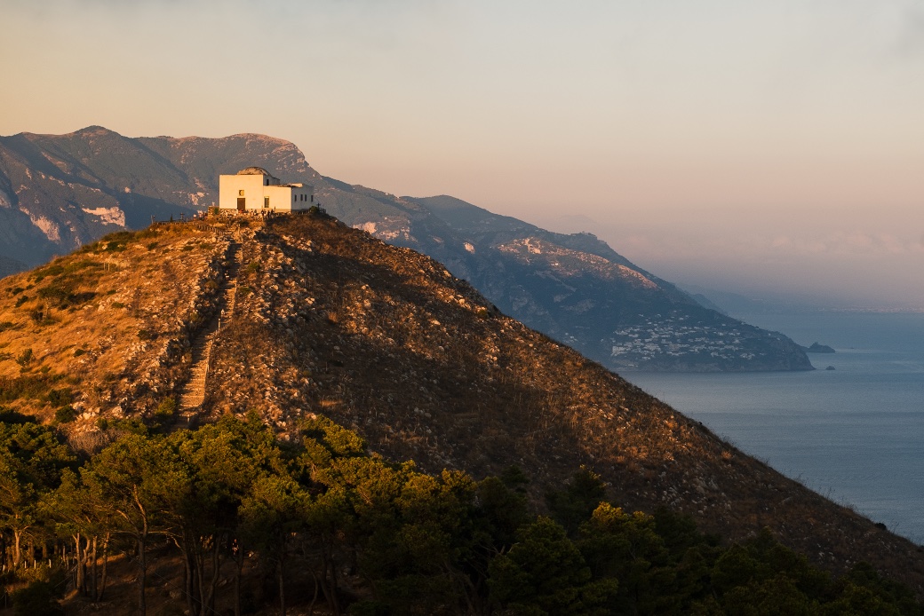 Exterior view of the Church of San Costanzo in Termini, Massa Lubrense. The historic church features traditional architecture in white , set against the backdrop of the charming hills of the Amalfi coast.
