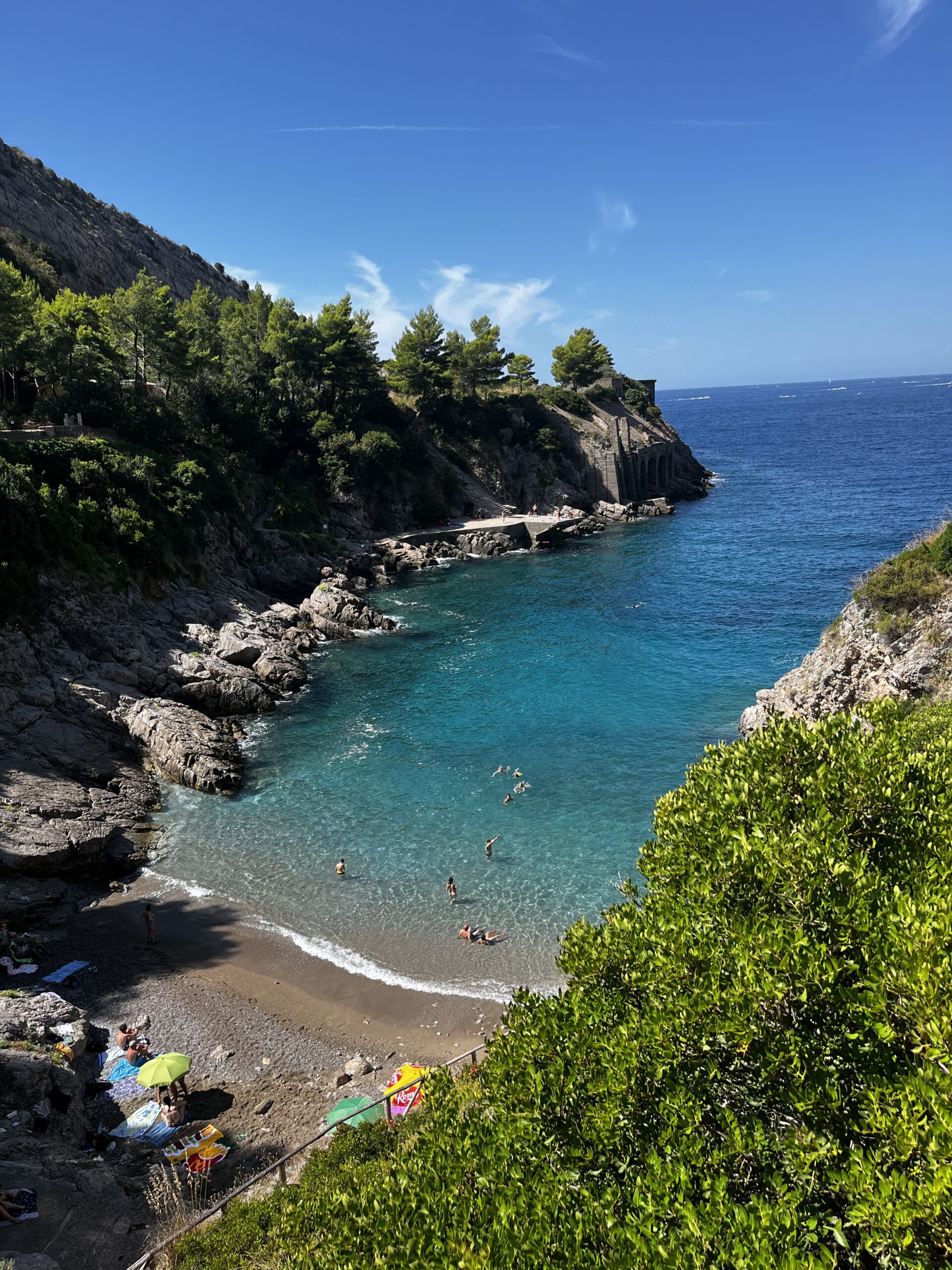 Breathtaking view of the sea from Jeranto Bay, showcasing crystal-clear turquoise waters surrounded by rugged cliffs and lush greenery. The serene and pristine beauty of this coastal landscape is captured in the image.