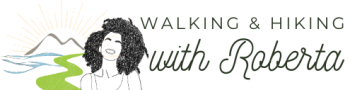 Logo featuring a vibrant sun rising over majestic mountains, with scenic Amalfi Coast trails in the background. A smiling girl leads a group of hikers, capturing the joy and camaraderie of our hiking adventures in Sorrento, Amalfi Coast, and Capri with 'Hiking with Roberta